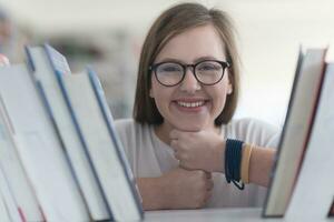 portrait d'une étudiante célèbre qui sélectionne un livre à lire dans la bibliothèque photo