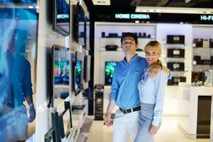 jeune couple dans un magasin d'électronique grand public photo