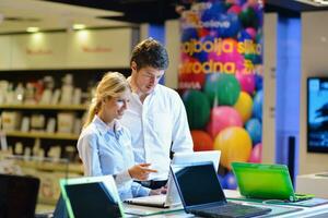 jeune couple dans un magasin d'électronique grand public photo