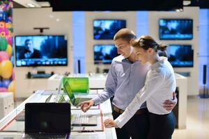 jeune couple dans un magasin d'électronique grand public photo