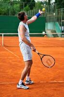 un homme joue au tennis dehors photo