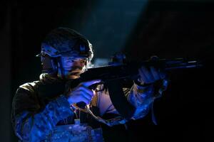 armée soldat dans combat uniformes avec un agression fusil et combat casque nuit mission foncé Contexte. bleu et violet gel lumière effet. photo