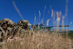 tireur d'élite soldat assisté par un assistant à observer le zone à être ciblé avec moderne guerre tactique virtuel réalité des lunettes de protection aérien drone militaire technologie. photo