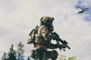 notion de guerre. un soldat barbu en uniforme des forces spéciales combattant un ennemi dans une zone forestière. mise au point sélective photo