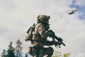 notion de guerre. un soldat barbu en uniforme des forces spéciales combattant un ennemi dans une zone forestière. mise au point sélective photo