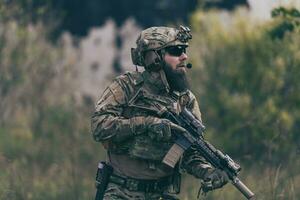 un soldat barbu en uniforme des forces spéciales dans une action militaire dangereuse dans une zone ennemie dangereuse. mise au point sélective photo