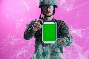 soldat montrant une tablette avec un écran vert vierge photo