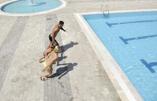 une jeune famille heureuse s'amuse à la piscine photo