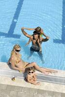 une jeune famille heureuse s'amuse à la piscine photo