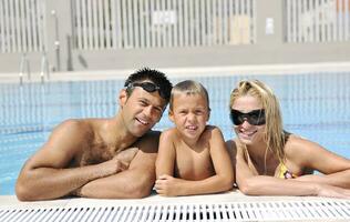 une jeune famille heureuse s'amuse à la piscine photo