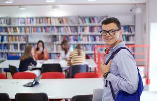 l'élève utilise un cahier, un ordinateur portable et une bibliothèque scolaire photo