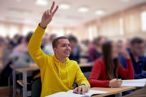 l'étudiant lève les mains en posant une question en classe au collège photo