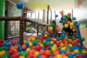 jeune maman avec ses enfants dans une salle de jeux pour enfants photo