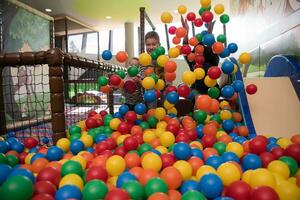 jeune maman avec ses enfants dans une salle de jeux pour enfants photo