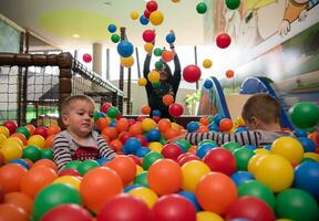 jeune maman avec ses enfants dans une salle de jeux pour enfants photo