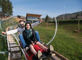 un couple aime conduire sur des montagnes russes alpines photo