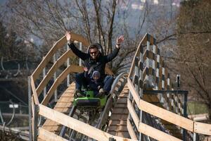 père et fils aime conduire sur les montagnes russes alpines photo