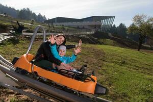 la mère et le fils aiment conduire sur les montagnes russes alpines photo