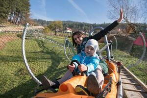 la mère et le fils aiment conduire sur les montagnes russes alpines photo