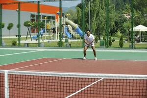 jeune homme jouer au tennis en plein air photo