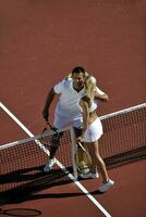 heureux jeune couple jouer au tennis en plein air photo