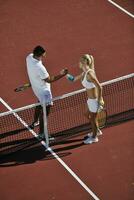 heureux jeune couple jouer au tennis en plein air photo