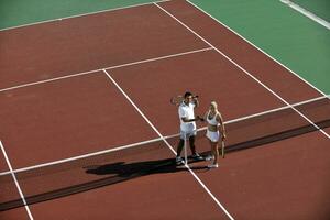 heureux jeune couple jouer au tennis en plein air photo