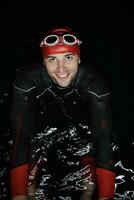 authentique nageur triathlète ayant une pause pendant un entraînement intensif la nuit photo