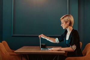 femme d'affaires séance dans une café tandis que concentré sur travail sur une portable et participant dans un en ligne réunions. sélectif se concentrer. haute qualité photo