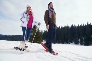 couple s'amusant et marchant en raquettes photo