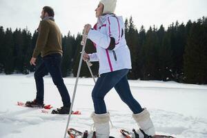 couple s'amusant et marchant en raquettes photo