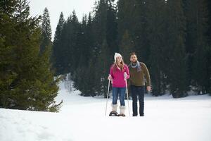 couple s'amusant et marchant en raquettes photo