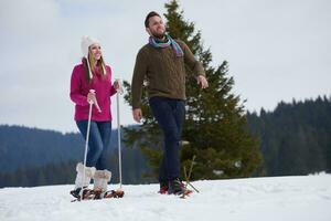 couple s'amusant et marchant en raquettes photo