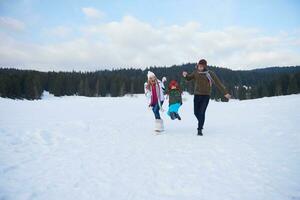 famille heureuse jouant ensemble dans la neige en hiver photo