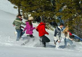 les amis s'amusent en hiver sur la neige fraîche photo