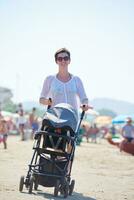 mère marchant sur la plage et poussant le landau photo