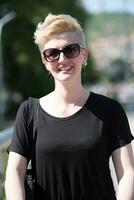 jeune femme aux cheveux blonds courts et lunettes de soleil photo