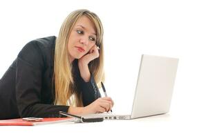 une jeune fille travaille sur un ordinateur portable isolé sur blanc photo