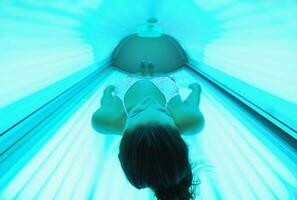 belle jeune femme bronzant au solarium photo