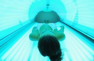 belle jeune femme bronzant au solarium photo