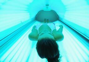 belle jeune femme bronzant au solarium photo