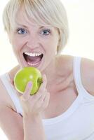 heureuse jeune femme mange une pomme verte isolée sur blanc photo