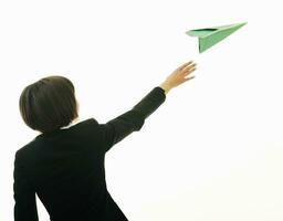 femme d'affaires jetant un avion en papier photo