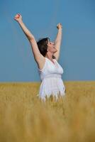 jeune femme dans un champ de blé en été photo