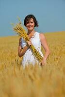 jeune femme dans un champ de blé en été photo