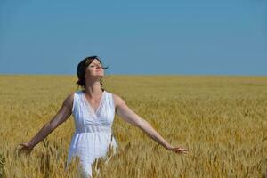 jeune femme dans un champ de blé en été photo