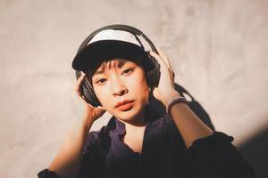 heureuse jeune femme asiatique écoutant de la musique avec des écouteurs photo