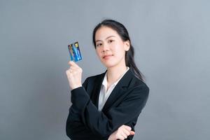 portrait d'une jolie jeune femme asiatique montrant une carte de crédit photo