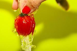 la main de dame lave la tomate