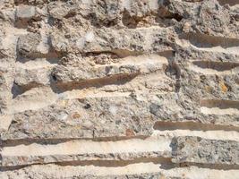 un mur fait de petites pierres de diverses roches et de ciment avec du sable